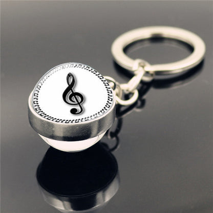 Llavero con colgante de piedra del tiempo y instrumento musical de piano