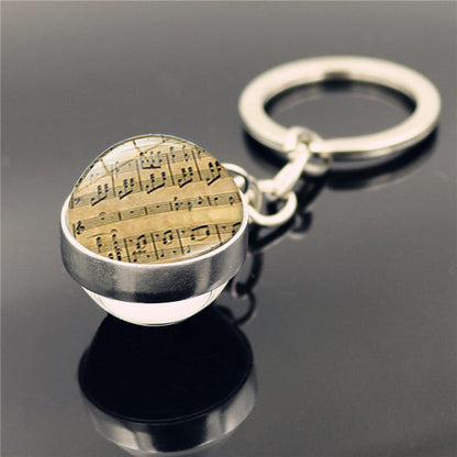 Llavero con colgante de piedra del tiempo y instrumento musical de piano
