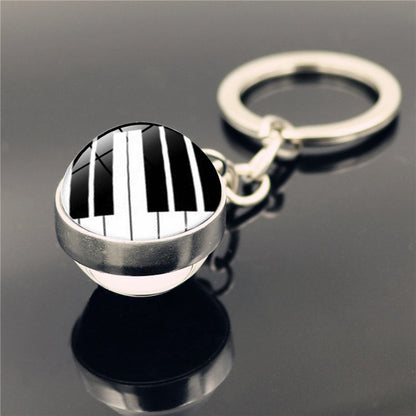 Llavero con colgante de piedra del tiempo y instrumento musical de piano